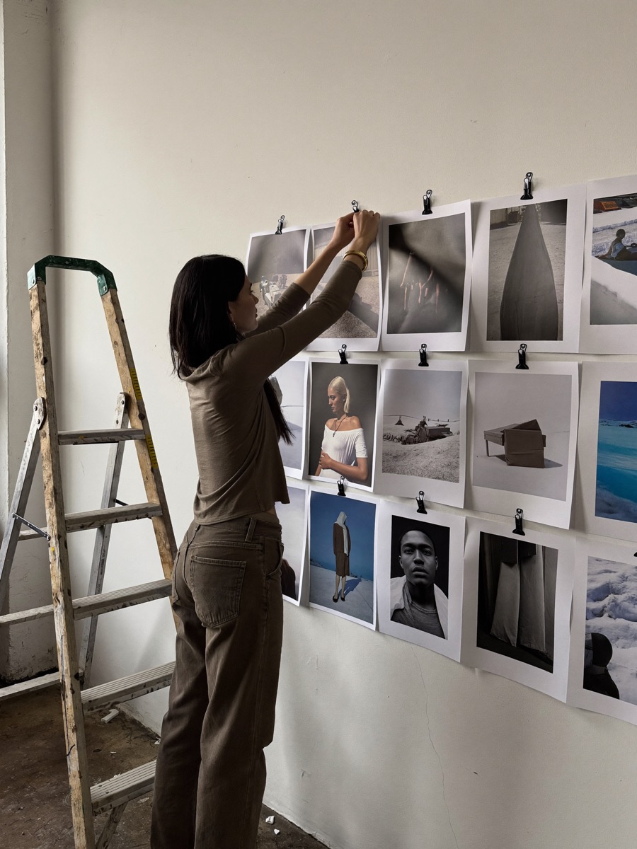 Photographer pinning prints to a studio wall